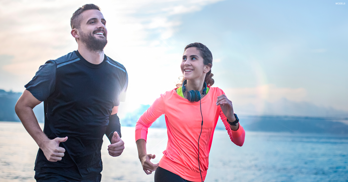 Couple running near the water.