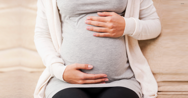 Pregnant woman holding her midsection.